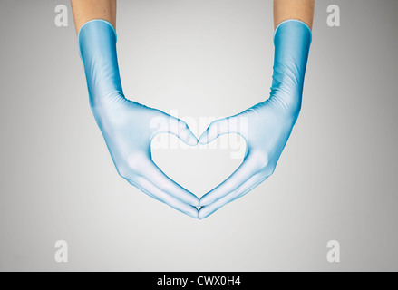Behandschuhten Händen machen Herzform Stockfoto