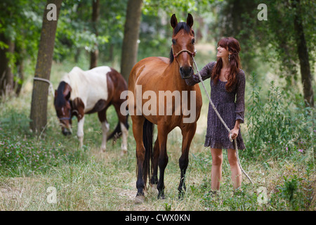 Frau Walking Pferd im Wald Stockfoto