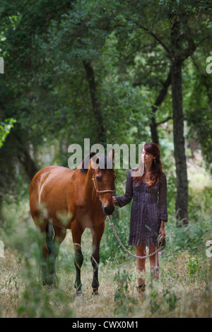 Frau Walking Pferd im Wald Stockfoto