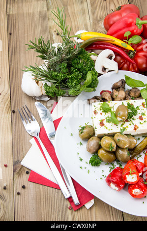 Gemischte Antipasti auf einer Platte gegen Holz Stockfoto