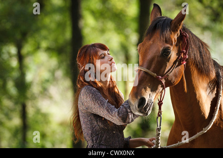 Frau Walking Pferd im Wald Stockfoto