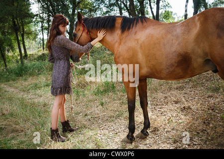 Frau Walking Pferd im Wald Stockfoto