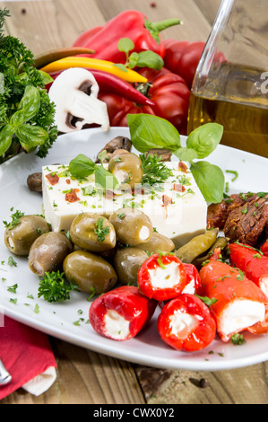 Gemischte Antipasti auf einer Platte gegen Holz Stockfoto