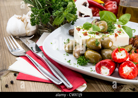 Gemischte Antipasti auf einer Platte gegen Holz Stockfoto