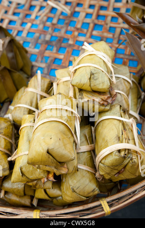 Thailand Delikatesse süßer Klebreis gewickelt im Bananenblatt auf Korb zum Verkauf in Bangkok Straße Lebensmittelmarkt. Stockfoto