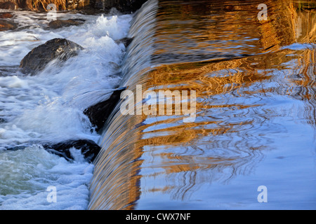 Baum-Reflexionen in Junction Creek fließt über den Staudamm, Greater Sudbury, Ontario, Kanada Stockfoto