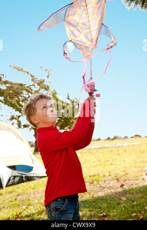 Ein 5 Jahre alter Junge hält einen Drachen. Stockfoto