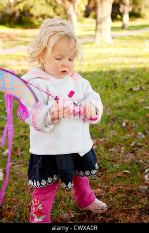 Kleine Mädchen spielen mit einem rosa Drachen. Stockfoto