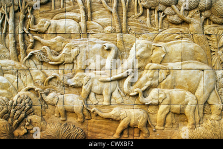 geschnitzte Elefanten auf der Steinmauer Stockfoto