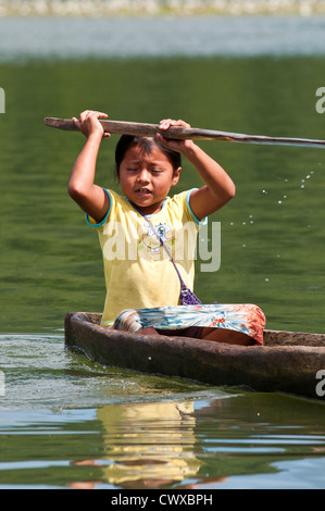 Junge einheimische einheimischen Garifuna Inderin paddeln ein Einbaum auf See Izabal, Lago de Izabal, Guatemala. Stockfoto