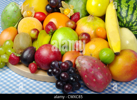 Exotische Früchte auf Holzbrett und Tischdecke Stockfoto