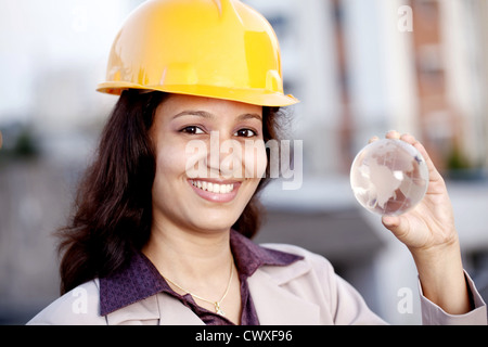 Fröhliche junge weibliche Bauingenieur mit einer Glaskugel Stockfoto