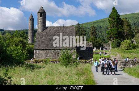 Touristen und Schule Reise nach St Kevins Kirche und Rundturm in Glendalough, County Wicklow, Irland Stockfoto