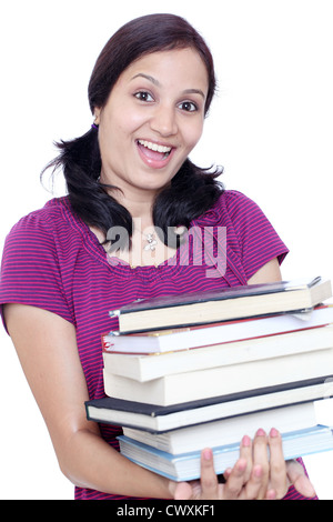 Glückliche junge Schülerin hält Stapel Bücher Stockfoto