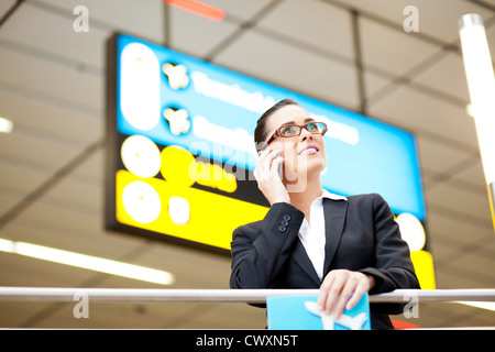 attraktive junge Geschäftsfrau, reden über Handy am Flughafen Stockfoto