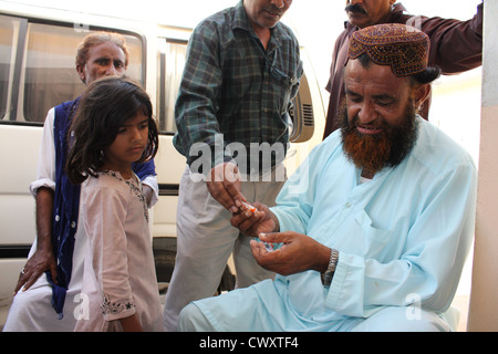 Flüchtling Mädchen immer bereit, ein Camp Setup für Flutopfer in Pakistan Cholera Impfung erhalten Stockfoto