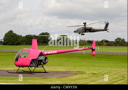 Kleine "und" Large - Robinson R22 Beta und RAF Apache Angriff Hubschrauber Anteil Wolverhampton Flughafen.  SCO 8373 Stockfoto