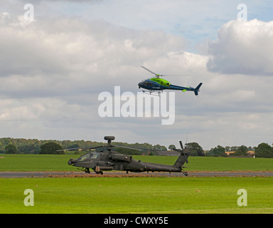 ALS 355N Twin Eichhörnchen Hubschrauber fliegen über eine RAF militärischen Apache AH-64 Kampfhubschrauber.  SCO 8381 Stockfoto