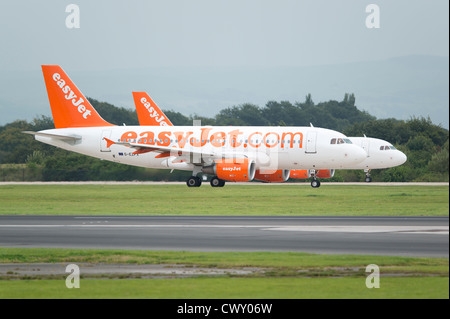 Zwei EasyJet Airbus A319 Flugzeuge saßen wartend auf der Landebahn des Manchester International Airport (nur zur redaktionellen Verwendung) Stockfoto