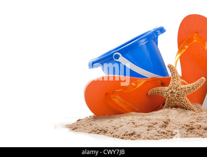 Strand-Szene mit Flip-Flops, sand, blau, Eimer und Seestern auf weiß mit Textfreiraum Stockfoto