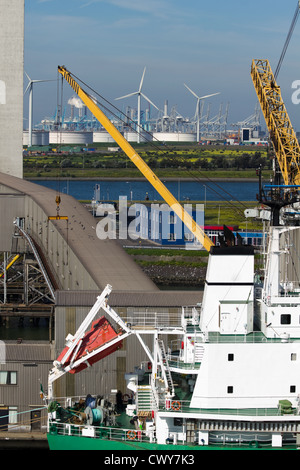 Nahaufnahme des Schiffes am Terminal mit Industriebauten und Windmühlen im Hintergrund Stockfoto