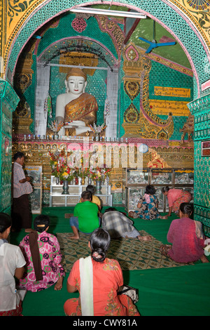 Myanmar, Burma. Sutaungpyei-Pagode, Mandalay Hill Tempel. Gläubige beten vor der Buddha-Statue. Stockfoto