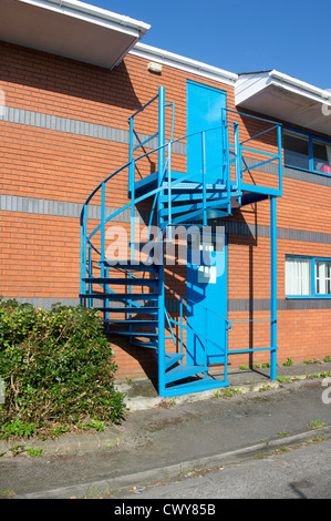 Blau lackierten Stahlspirale Treppe Feuertreppe auf Seite des Industriebaus Stockfoto