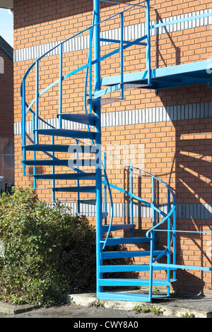 Blau lackierten Stahlspirale Treppe Feuertreppe auf Seite des Industriebaus Stockfoto
