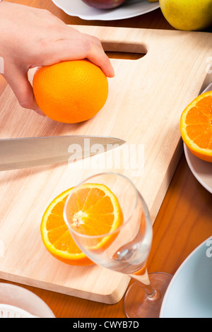 Detail des Schneidens gesunde frische Orangen auf Schneidebrett. Stockfoto