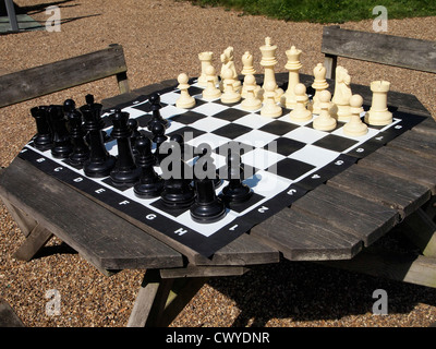 große Outdoor-Schachspiel und Brett auf einem Picknicktisch. Stockfoto