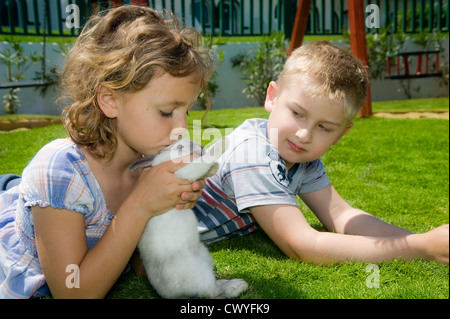 Jungen und Mädchen spielen mit einem Kaninchen Stockfoto