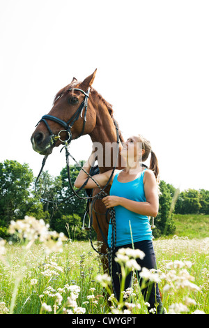 Teenager-Mädchen mit Pferd auf der Wiese Stockfoto