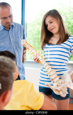 Schulmädchen zeigen Wirbelsäule Modell in der Klasse Stockfoto