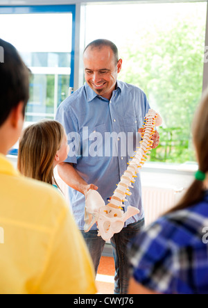 Lehrer zeigt Wirbelsäule Modell in der Klasse Stockfoto