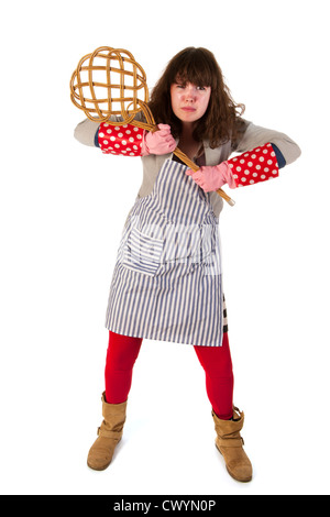 Hausfrau ist sehr wütend auf Teppichklopfer in Händen Stockfoto