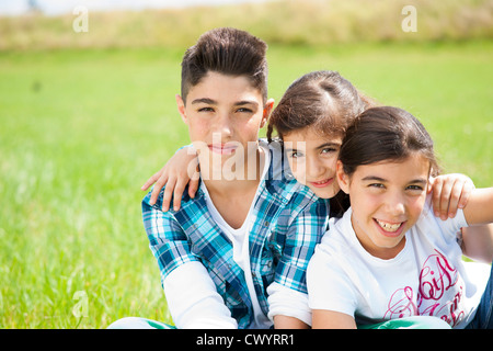 Drei Kinder sitzen auf der Wiese Stockfoto