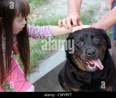 Kleines Mädchen mit einem großen schwarzen Hund Stockfoto