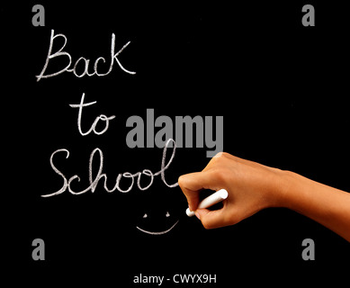 Handschrift phrase "back to School" an die Tafel im Klassenzimmer, Konzeptbild der Schulzeit, Lehrer Arm holding Kreide Stockfoto