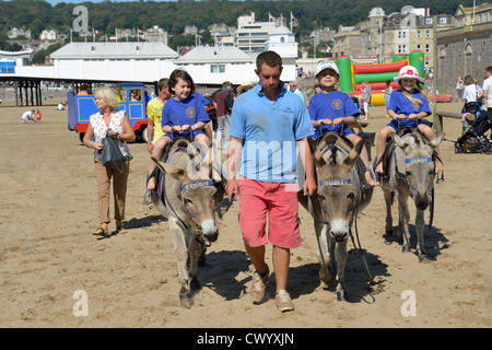 Eselreiten für Kinder am Strand, Weston-Super-Mare, Somerset, England, Vereinigtes Königreich Stockfoto