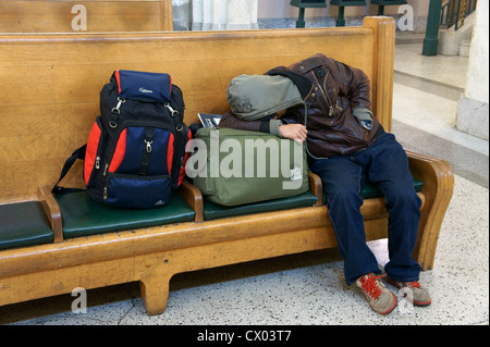 Schlafen männlichen Reisenden Taling ein Nickerchen auf einer Holzbank, Pacific Central Railway Station, Vancouver, Britisch-Kolumbien, Kanada Stockfoto