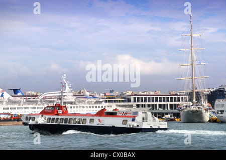 Die abwechslungsreiche Schiffsverkehr (ein Hellenic Seaways Flying Dolphin, eine Rolle auf Roll off Fähre und eine touristische Kreuzer Großsegler) in Piräus Stockfoto