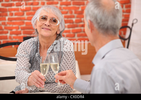 älteres Ehepaar im Restaurant Toasten Stockfoto