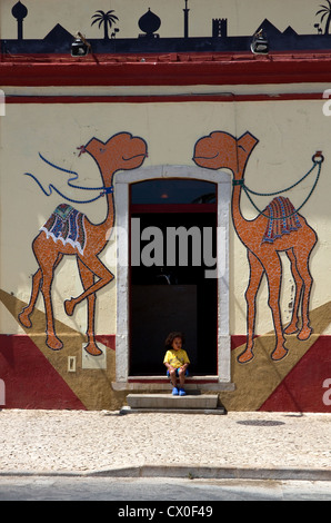 Junges Kind auf Stufen des Dromedario Café in Sagres, Algarve, Portugal Stockfoto