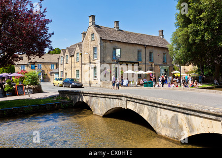 Cotswolds Dorf mit einer alten Steinbrücke über den Fluss Windrush durchkämmt das Zentrum von Bourton am Wasser Gloucestershire England GB Europa Stockfoto