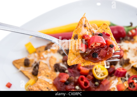 Nachos auf einer Gabel vor weißem Hintergrund Stockfoto