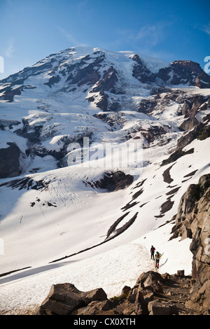 Kletterer Abstieg vom Mount Rainier über den Skyline Trail mit dem Nisqually Gletscher im Hintergrund. Washington, USA. Stockfoto