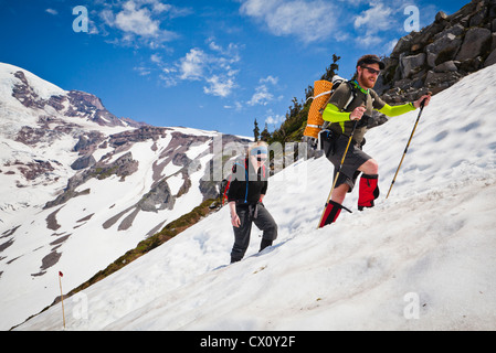 Ein Mann und eine Frau machen ihren Weg bis Mount Rainier auf dem Skyline Trail, Washington, USA. Stockfoto