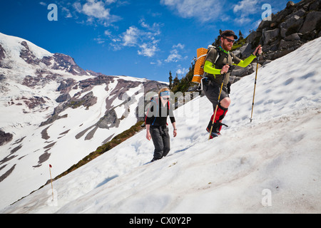 Ein Mann und eine Frau machen ihren Weg bis Mount Rainier auf dem Skyline Trail, Washington, USA. Stockfoto