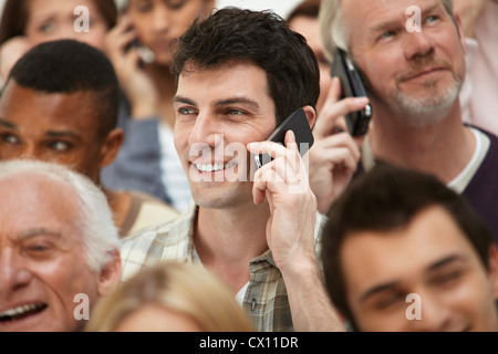 Mann am Handy mit Personengruppe Stockfoto