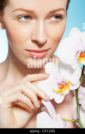 Frau Holding Orchideen Stockfoto